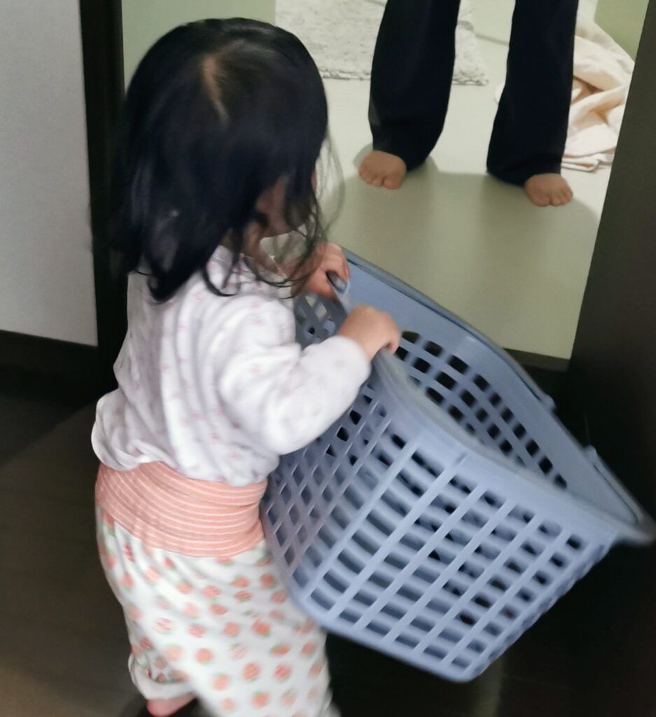 洗濯カゴを両手で運ぶ子供