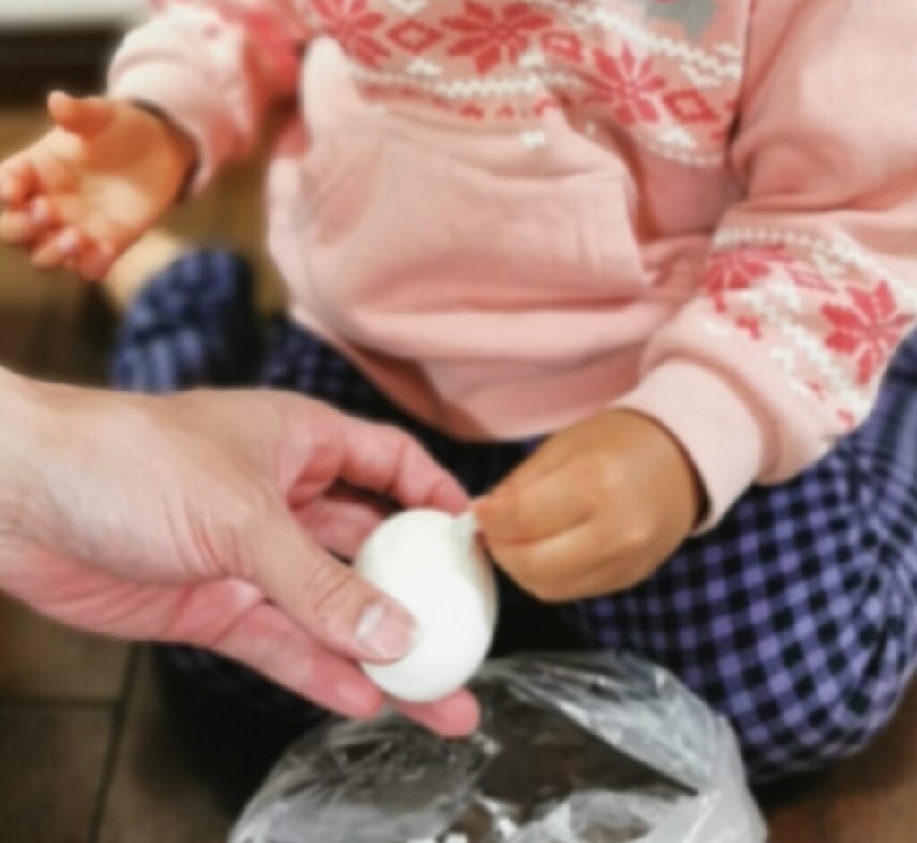 子供がゆで卵を剥いているところ