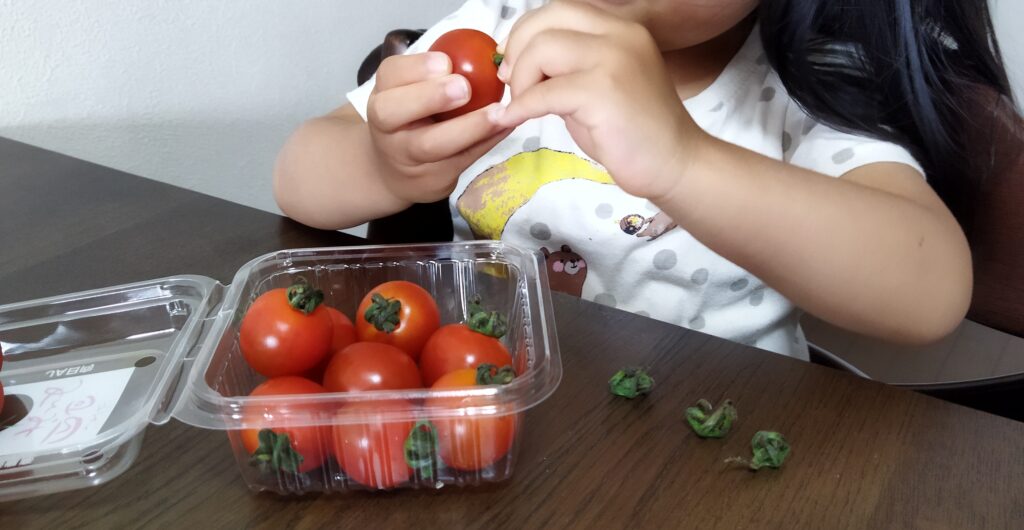 プチトマトのヘタをとる子供