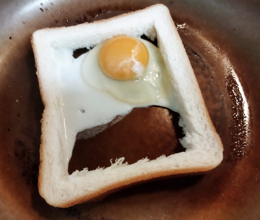 食パンの内側へ卵を割り落した様子
