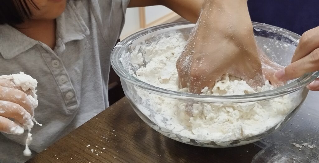 小麦粉に塩水を加えて混ぜる様子